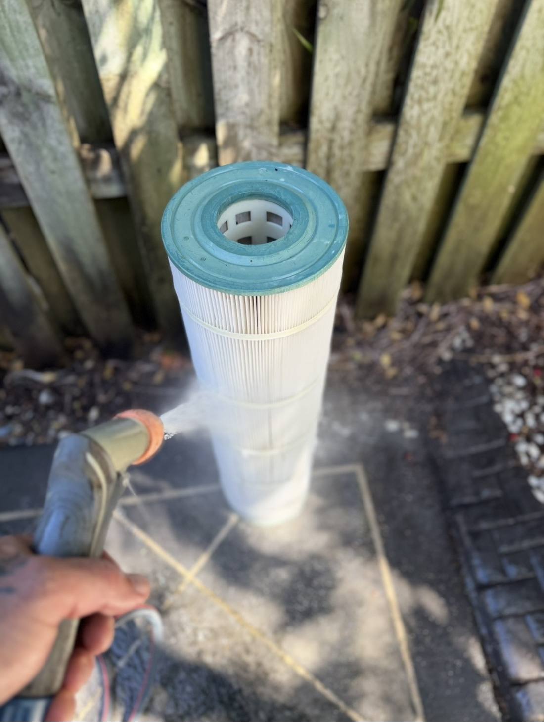 Pool filter cartridge being pressure cleaned by Blue Avenue Pools